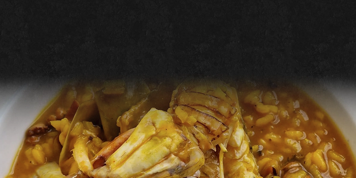 fondo de pizarra con paellera con paella de marisco encima